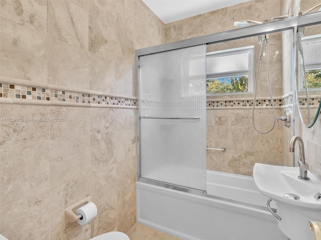 full bathroom featuring a wealth of natural light, combined bath / shower with glass door, and tile walls