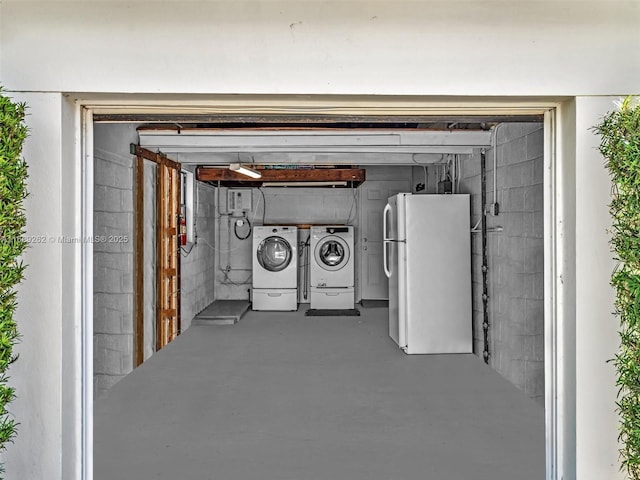 basement featuring independent washer and dryer and white fridge