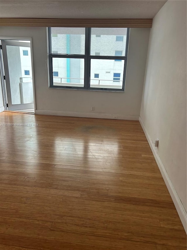 unfurnished room featuring a wealth of natural light and wood finished floors