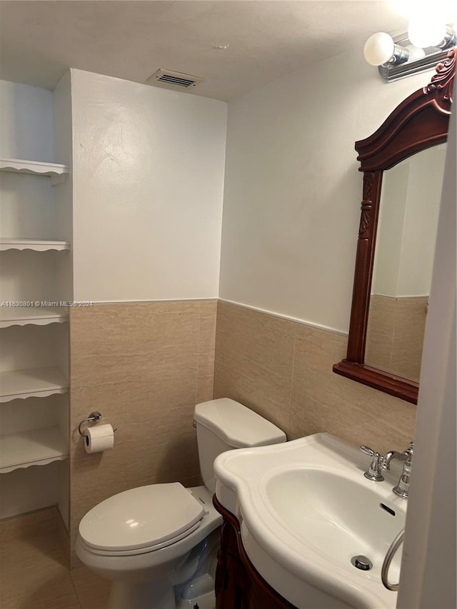 bathroom featuring tile walls, toilet, and vanity