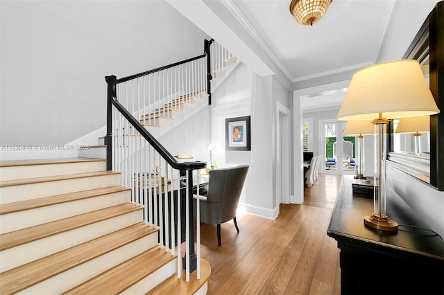 stairs with hardwood / wood-style floors and ornamental molding