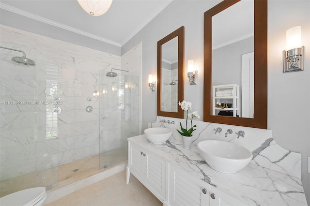 bathroom featuring tile patterned flooring, crown molding, toilet, tiled shower, and vanity