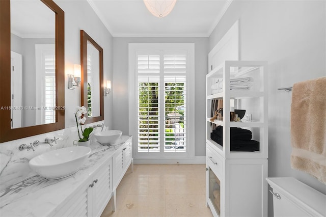 bathroom featuring tile patterned flooring, vanity, toilet, and crown molding