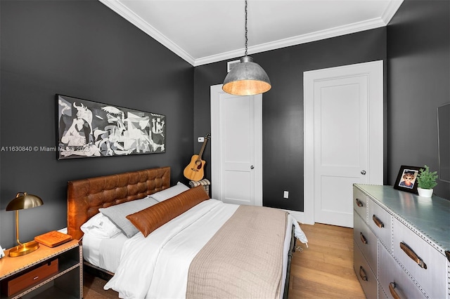 bedroom featuring light hardwood / wood-style floors and crown molding