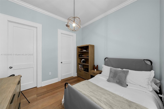 bedroom featuring crown molding, an inviting chandelier, and light wood-type flooring