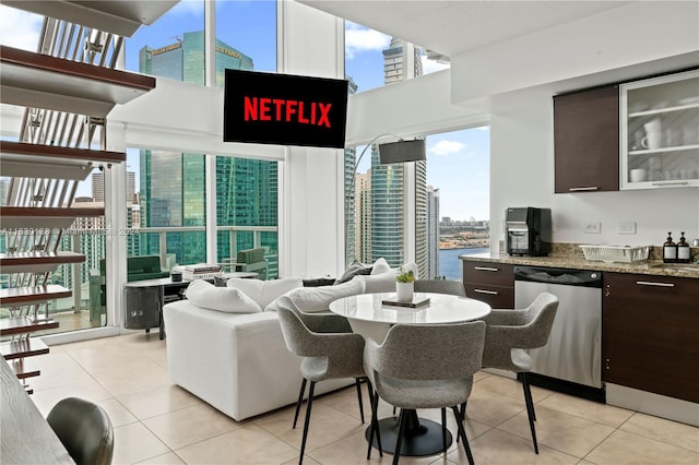 dining area featuring a water view and light tile patterned flooring