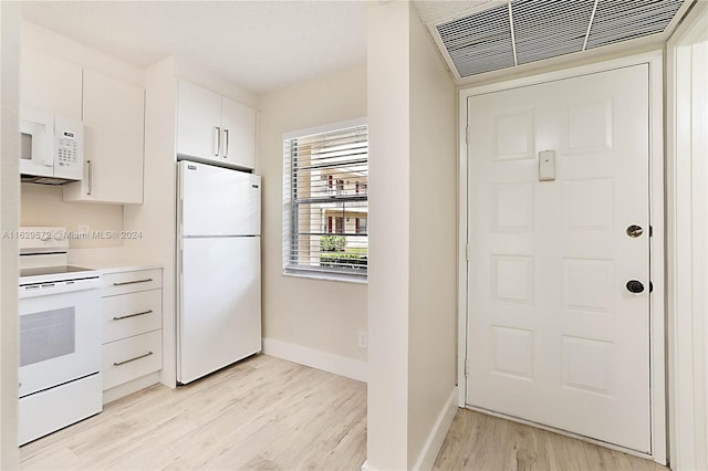 kitchen with white cabinets, white appliances, and light hardwood / wood-style floors