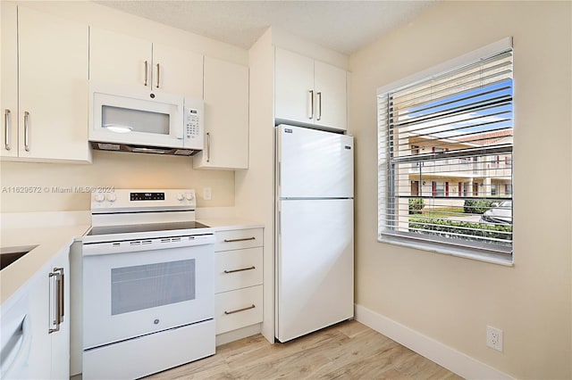 kitchen with white appliances, light wood-type flooring, and white cabinetry