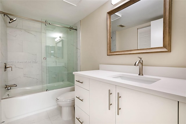 full bathroom with toilet, bath / shower combo with glass door, vanity, and tile patterned flooring