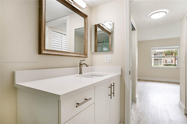 bathroom featuring a textured ceiling, vanity, and wood-type flooring