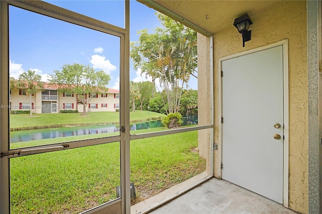 unfurnished sunroom featuring a water view