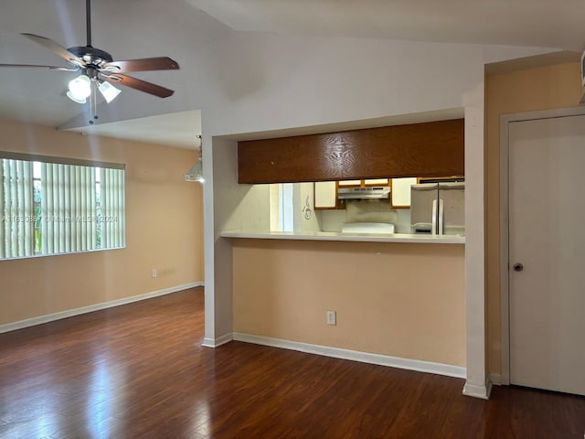 kitchen featuring dark hardwood / wood-style flooring, stainless steel fridge, ceiling fan, and vaulted ceiling