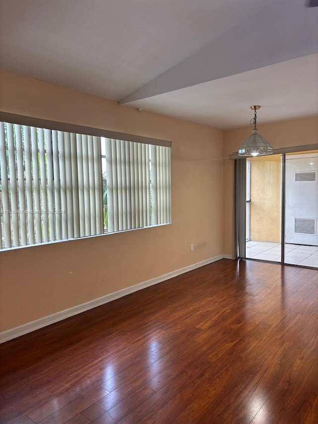 empty room featuring dark hardwood / wood-style floors and vaulted ceiling