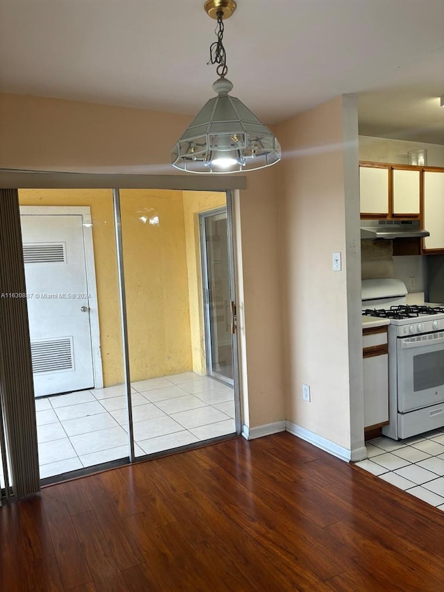 interior space with pendant lighting, white range with gas stovetop, and light hardwood / wood-style flooring