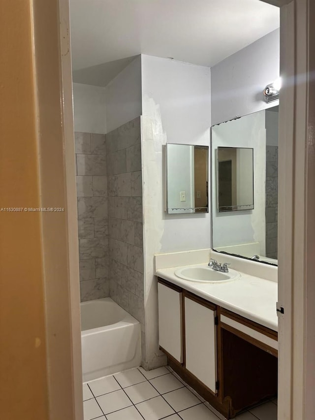 bathroom featuring tiled shower / bath, vanity, and tile patterned flooring