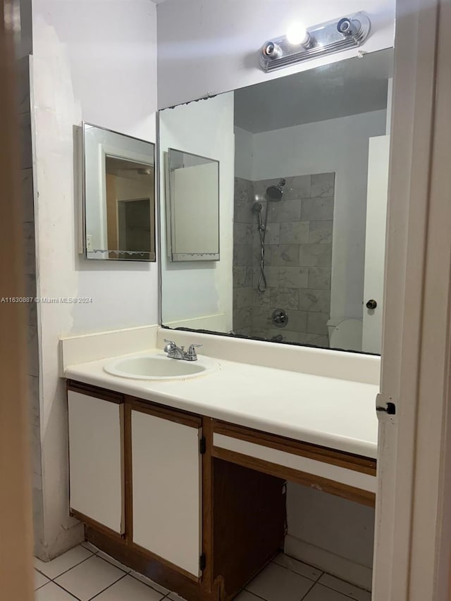 bathroom with tile patterned floors, vanity, and a tile shower