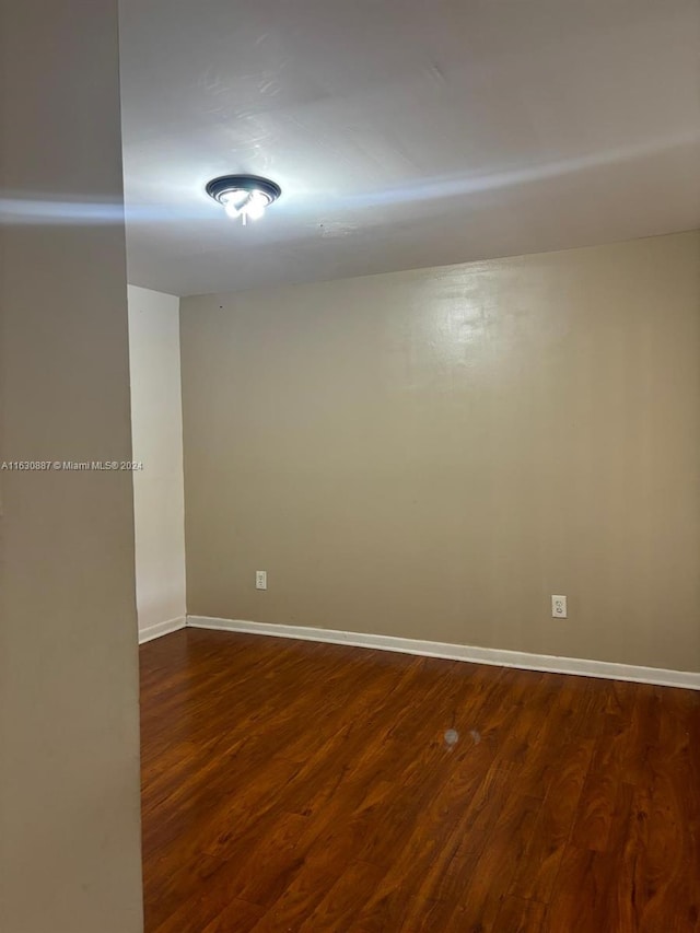 spare room featuring dark wood-type flooring