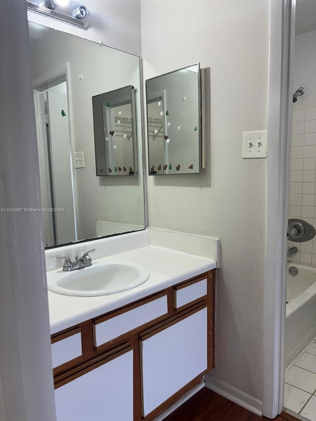 bathroom with tiled shower / bath combo and vanity