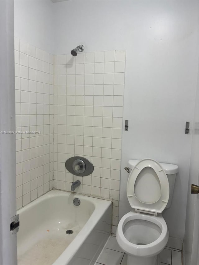 bathroom featuring tiled shower / bath and toilet