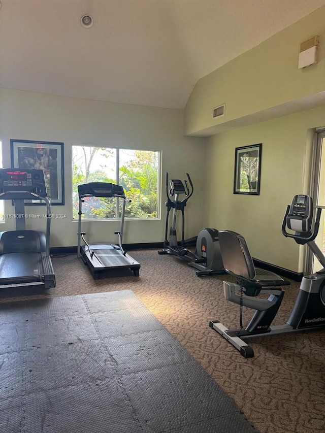 workout area with vaulted ceiling and dark colored carpet