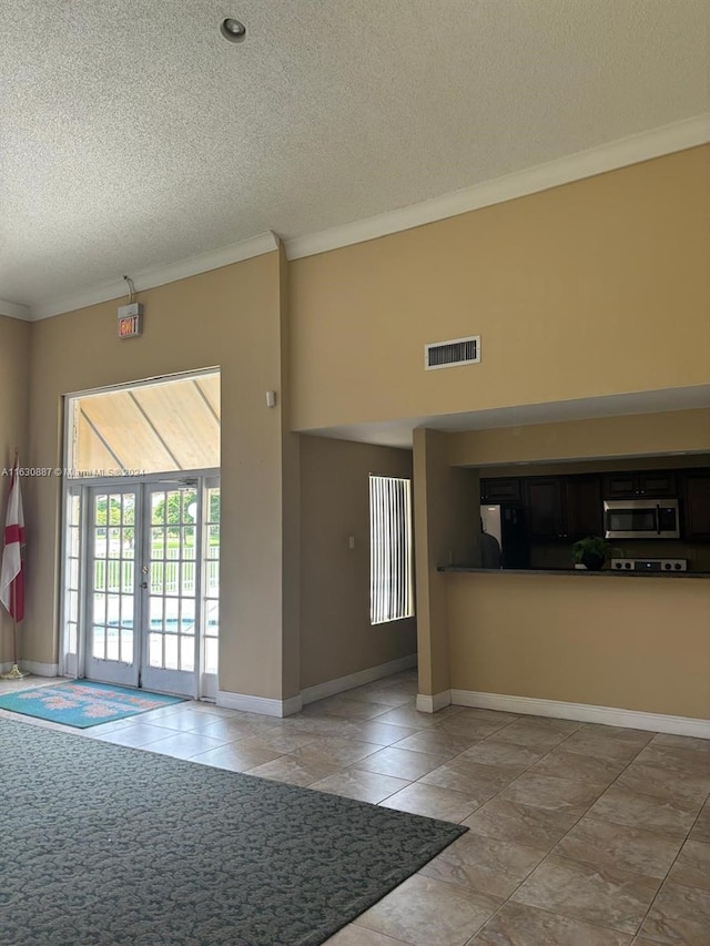 interior space with ornamental molding, french doors, and a textured ceiling