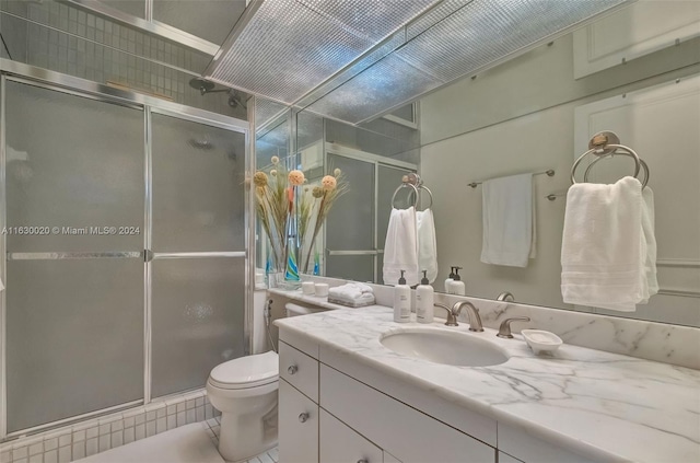 bathroom with walk in shower, vanity, tile patterned flooring, and toilet