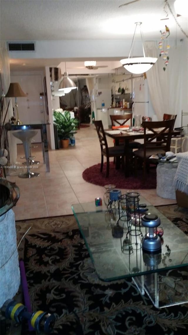 dining area with tile patterned flooring and a textured ceiling