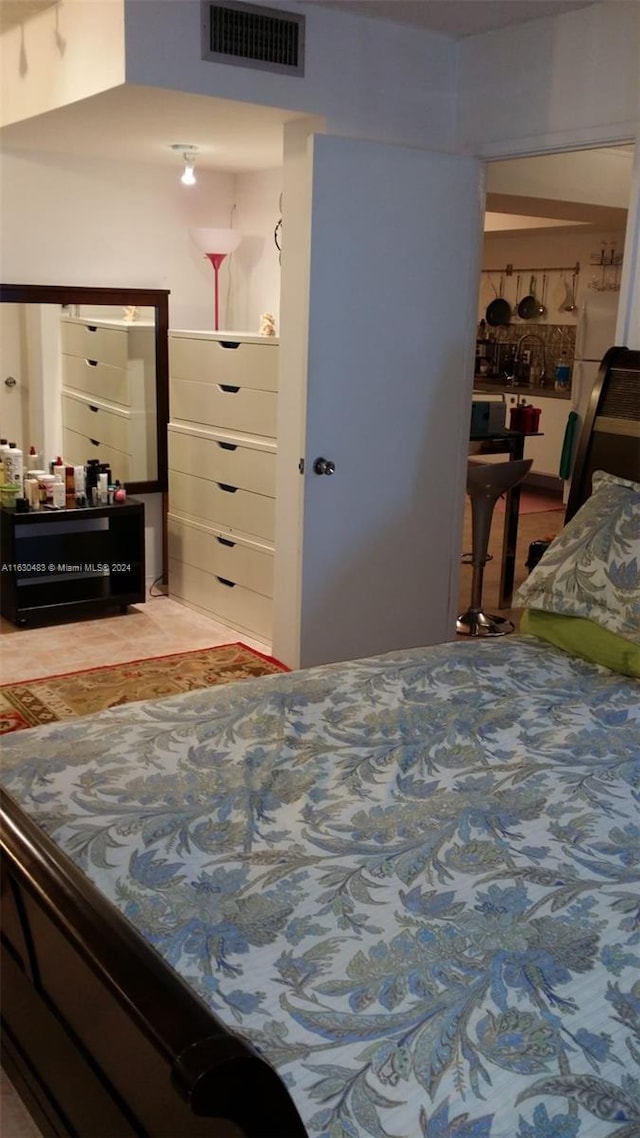 bedroom with white refrigerator and hardwood / wood-style flooring