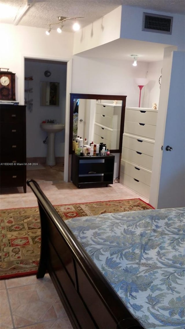 tiled bedroom with sink and a textured ceiling