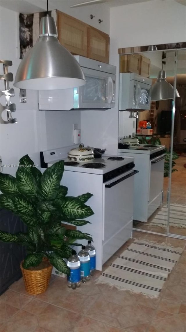 kitchen with light tile patterned floors and white appliances