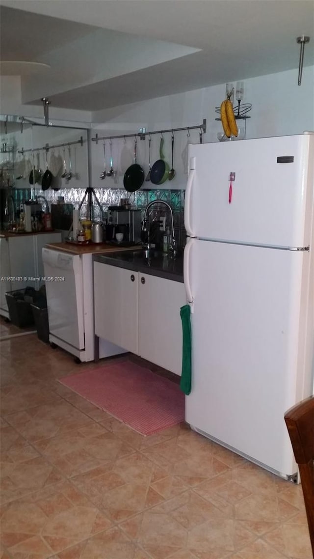 kitchen with sink, white appliances, and light tile patterned floors