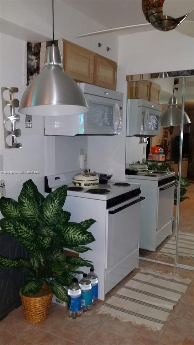 kitchen featuring light tile patterned flooring and white appliances