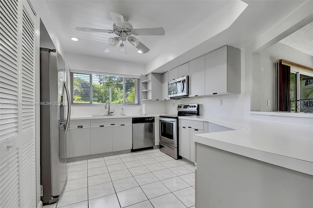 kitchen featuring light tile patterned flooring, ceiling fan, stainless steel appliances, sink, and gray cabinetry