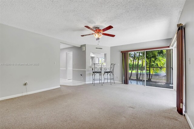 spare room with carpet flooring, a textured ceiling, and ceiling fan