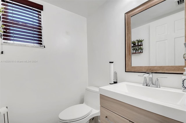 bathroom featuring toilet, vanity, and radiator heating unit