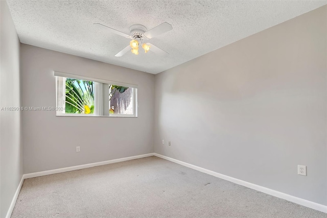 carpeted spare room with a textured ceiling and ceiling fan