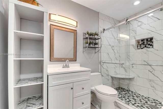 bathroom featuring vanity, tile patterned floors, toilet, and an enclosed shower