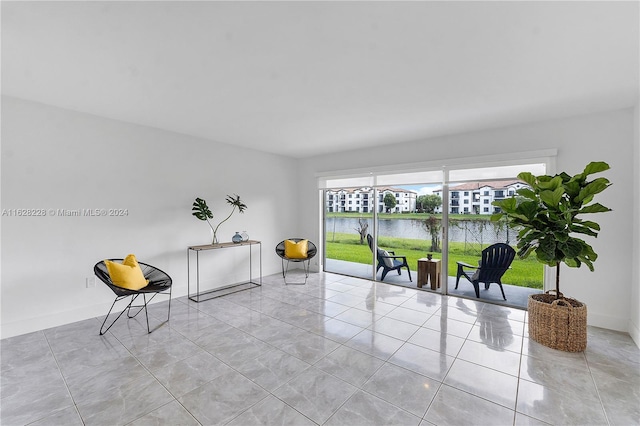 living area with a water view and light tile patterned floors