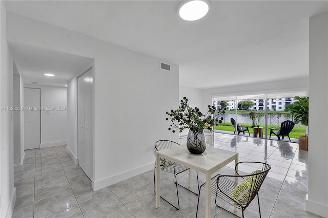 tiled dining area featuring a water view