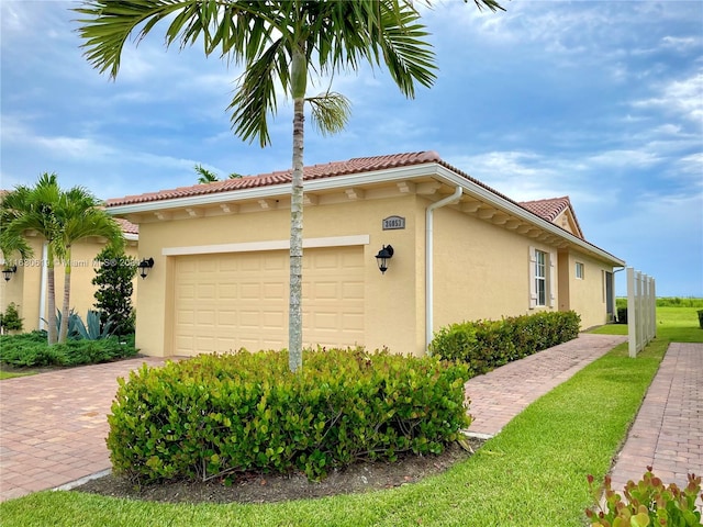 view of property exterior with a garage and a lawn