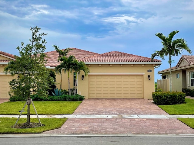 mediterranean / spanish-style home with a garage and a front yard