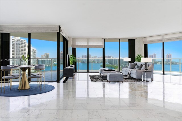 living room featuring plenty of natural light, light tile patterned flooring, and a wall of windows