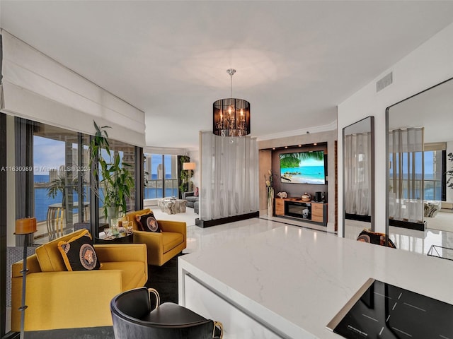 living room with a water view and a notable chandelier