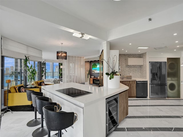 kitchen with black appliances, tasteful backsplash, beverage cooler, pendant lighting, and light tile patterned floors