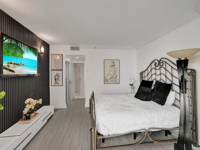 bedroom with wood-type flooring and ornamental molding