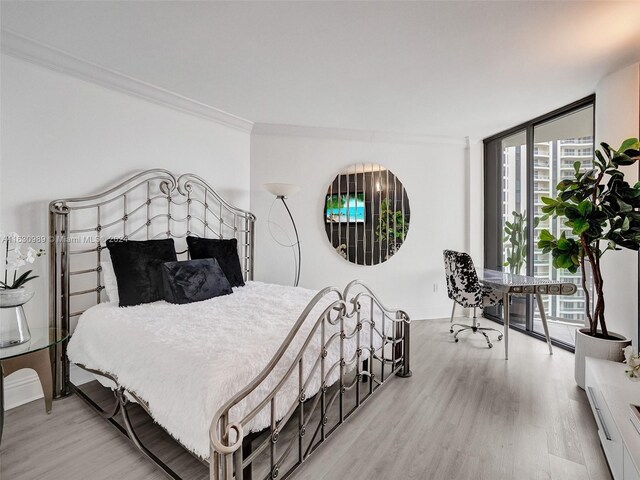 bedroom featuring ornamental molding and light hardwood / wood-style floors