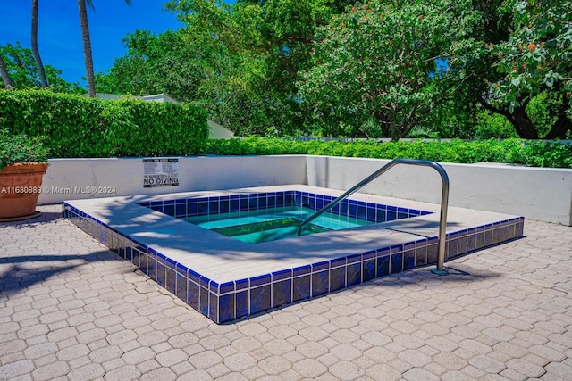 view of swimming pool featuring a hot tub and a patio area