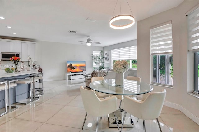 dining space with ceiling fan and light tile patterned floors