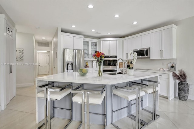 kitchen featuring appliances with stainless steel finishes, a large island, a breakfast bar, and white cabinets