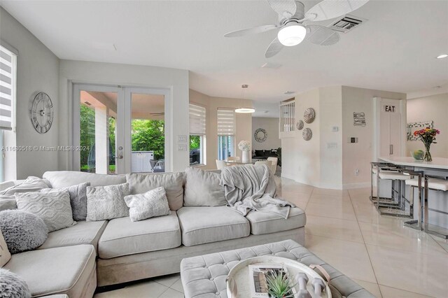 living room with light tile patterned flooring, a healthy amount of sunlight, ceiling fan, and french doors